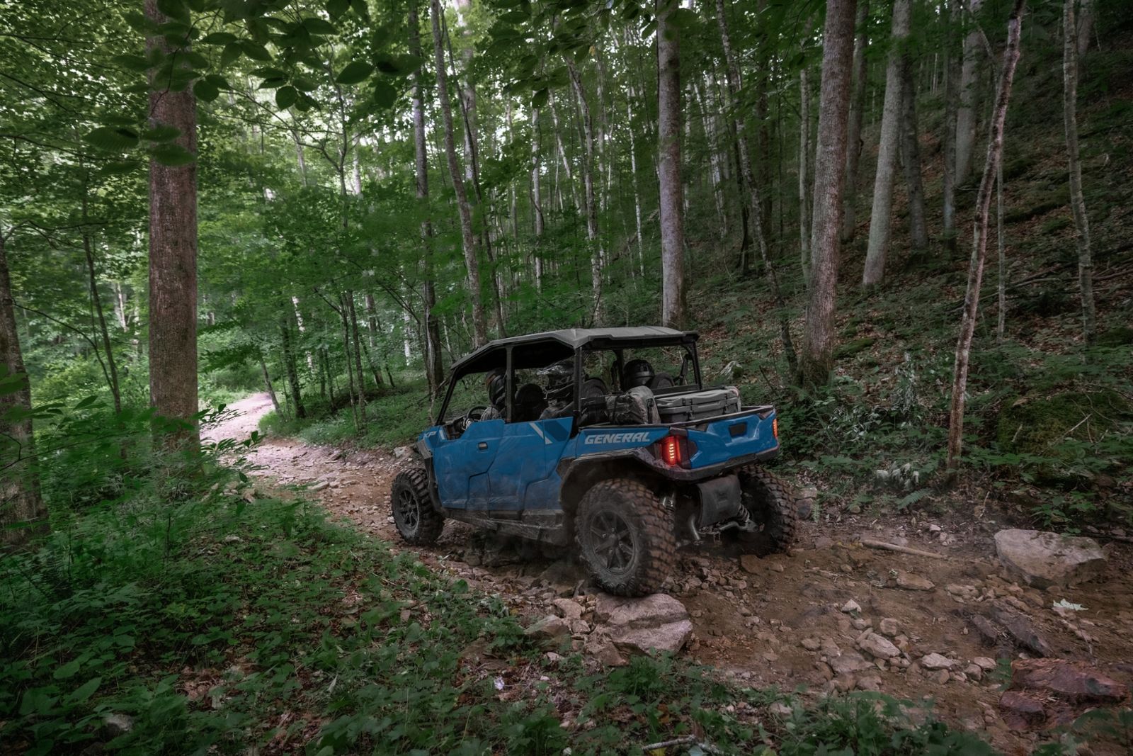 Blue side-by-side on a forest trail