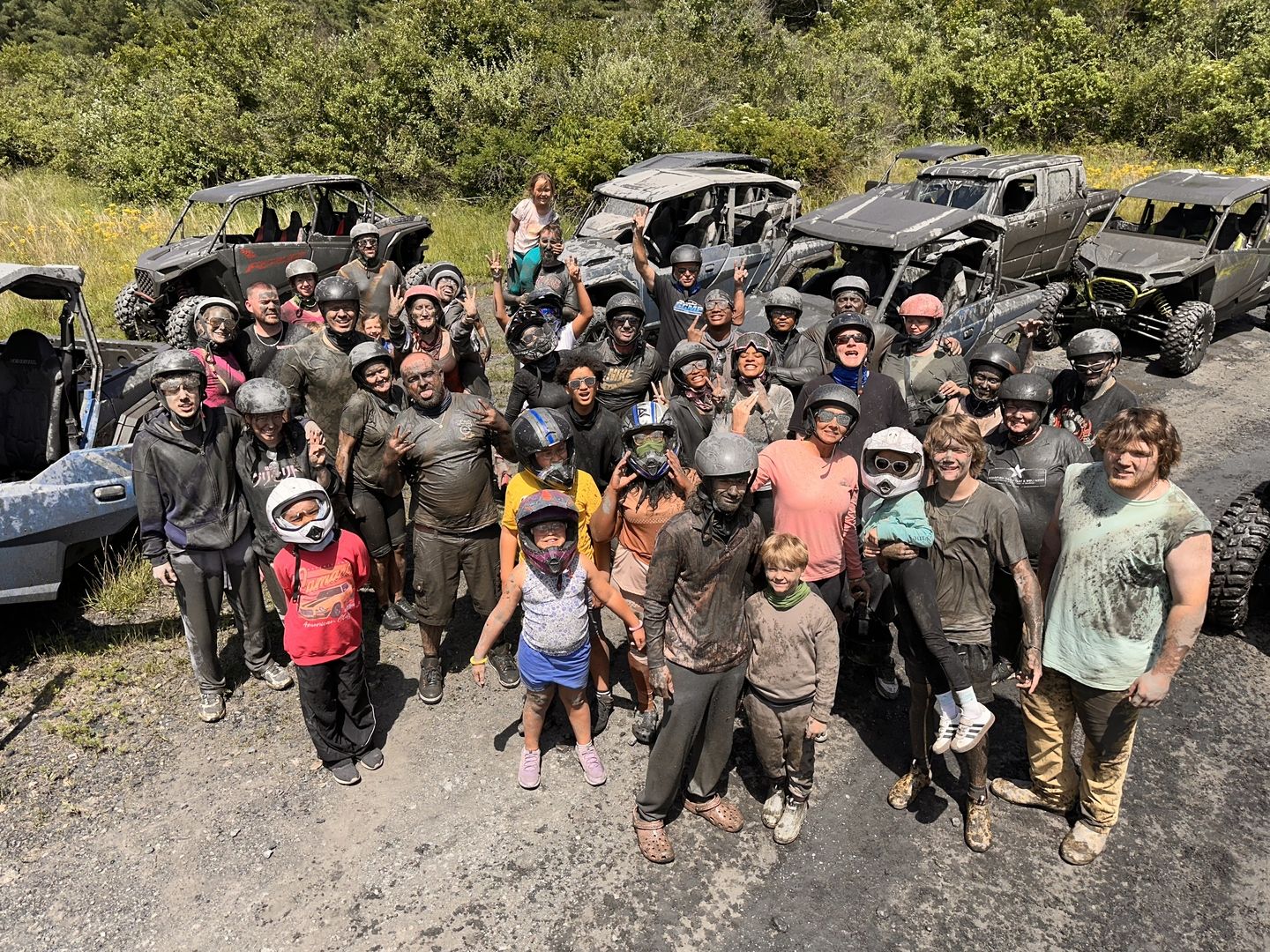 Large group of riders posing with their side-by-sides